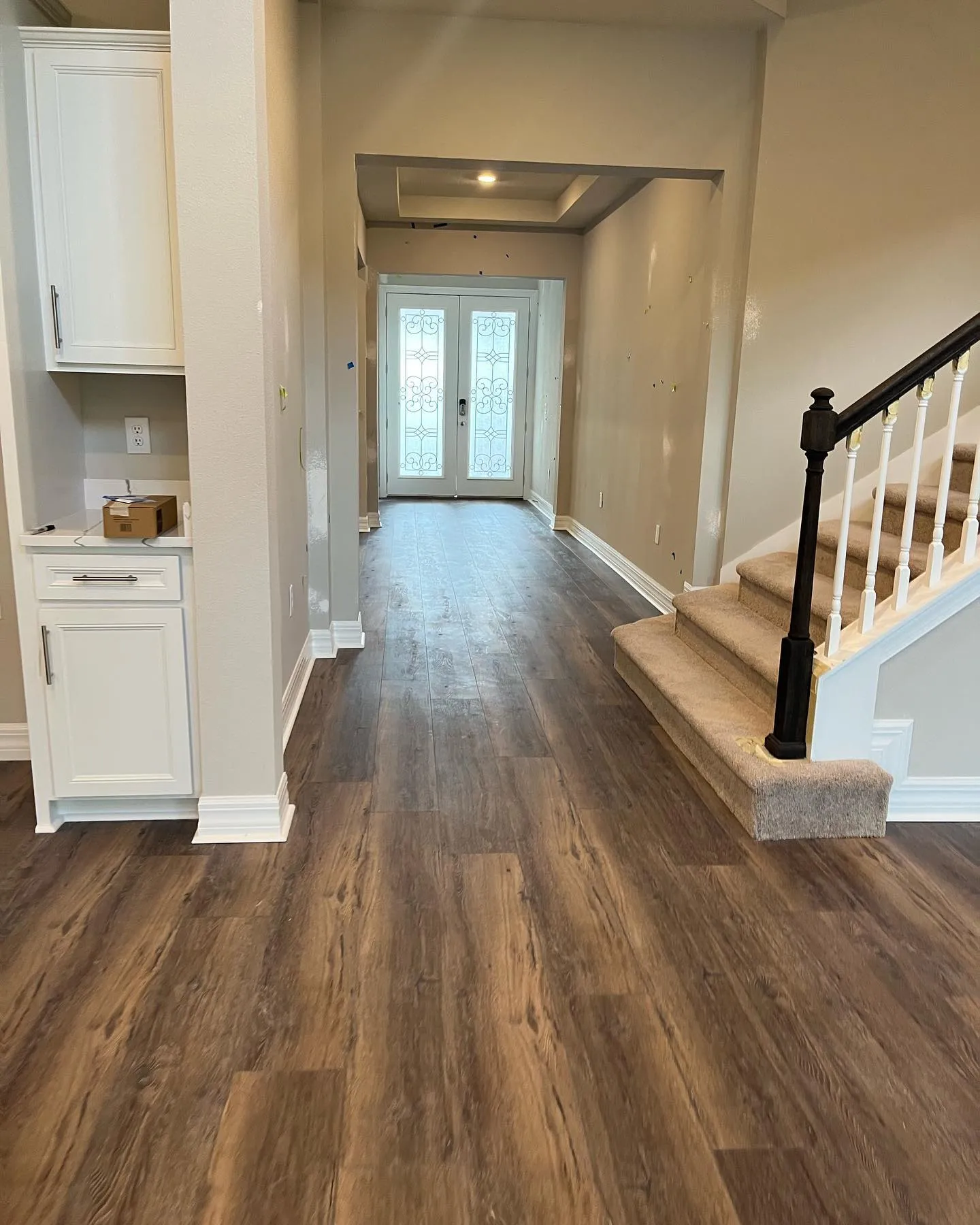 Vinyl plank entryway with staircase and baseboards